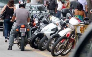 Transito: Com as vagas totalmente tomadas, um motociclista encontra dificuldades para estacionar 